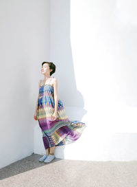 Full length of young woman standing by railing