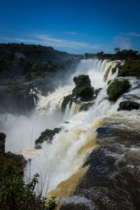 Scenic view of waterfall against sky