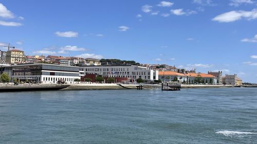 Sea by buildings against sky in city