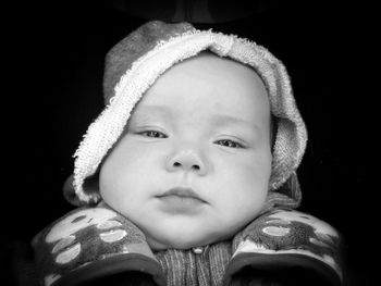 Close-up portrait of baby boy against black background