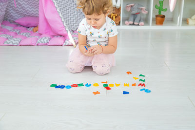High angle view of cute girl playing with toys on floor