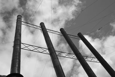 Low angle view of silhouette telephone pole against sky