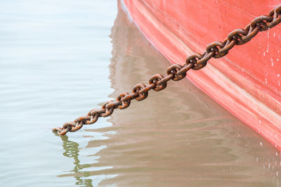 Close-up of chain hanging over lake