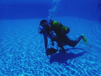 Man underwater diving in swimming pool