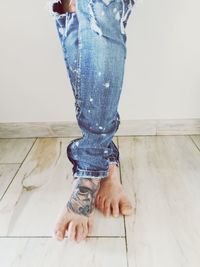 Low section of man standing on hardwood floor