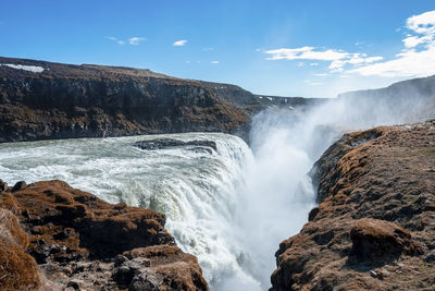 Powerful cascades of gullfoss waterfall in scenic golden circle against blue sky