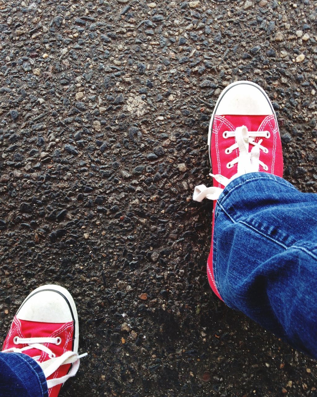 shoe, low section, person, personal perspective, footwear, standing, high angle view, lifestyles, canvas shoe, jeans, human foot, leisure activity, street, red, men, unrecognizable person, pair