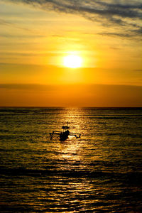 Silhouette boat in sea against sky during sunset