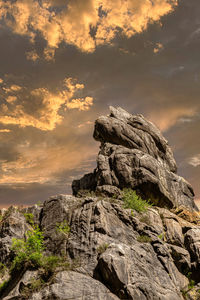 Rock formation on land against sky during sunset