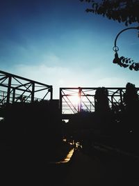 Low angle view of silhouette rollercoaster against sky at sunset