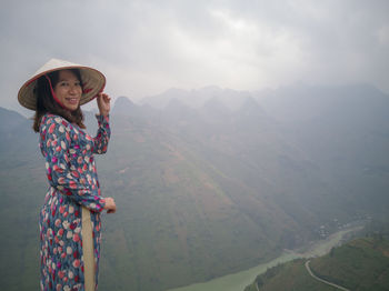 Portrait of smiling girl standing against mountains