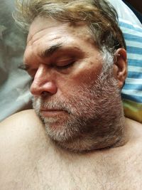 Close-up of mature man sleeping on bed at home