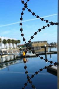 Close-up of chainlink fence against blue sky