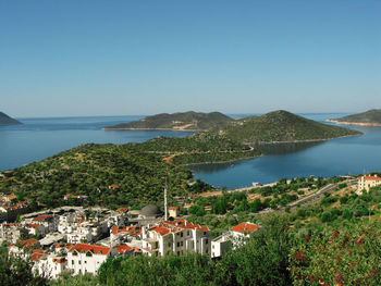 High angle view of town by sea against clear sky