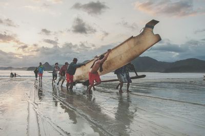 Men on beach against sky