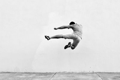 Man in mid-air against wall