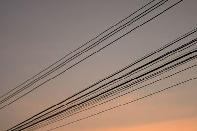 Low angle view of power lines against sky