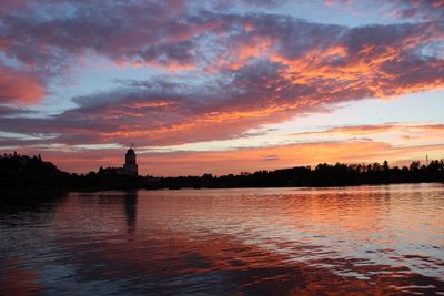 Scenic view of river against sky at sunset