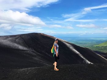 Portrait of woman standing on mountain against sky