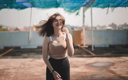 Smiling teenage girl standing on footpath