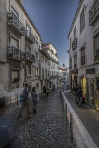 People walking on street amidst buildings in city