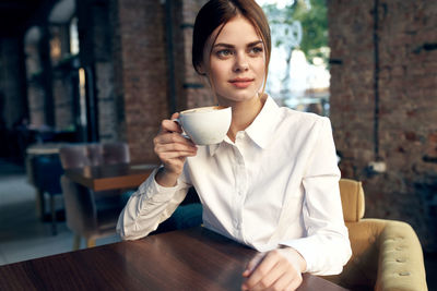 Mid adult woman with coffee cup in cafe