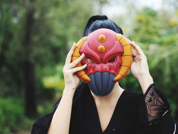 Portrait of a young woman holding a covering face