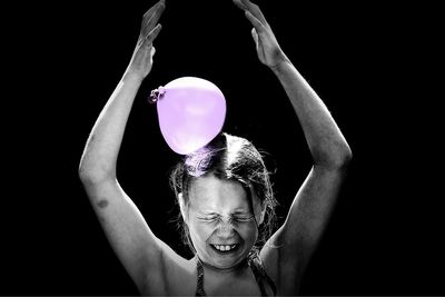 Portrait of girl wearing mask against black background