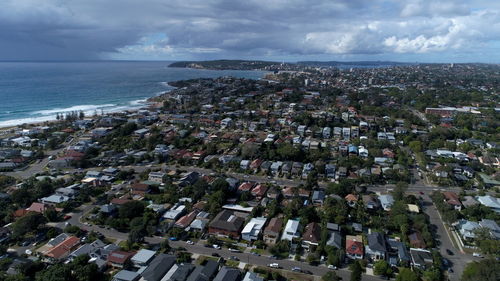 High angle view of townscape by sea against sky