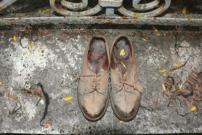 High angle view of old shoes on footpath