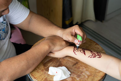 Midsection of couple holding hands on table