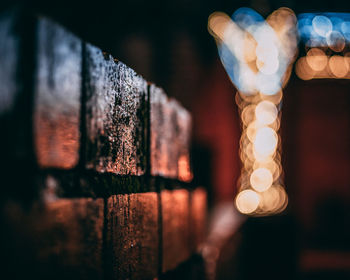 Close-up of illuminated light against wall at night