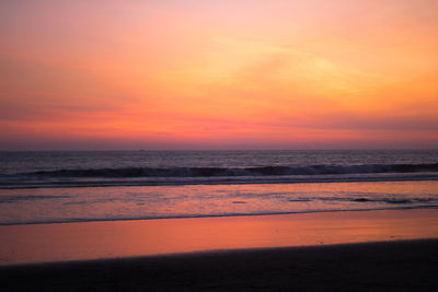 Scenic view of sea against dramatic sky during sunset