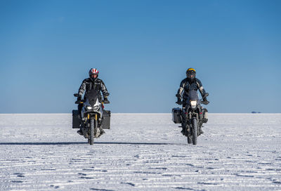 Two men riding touring motorbike's on the salt flats of uyuni