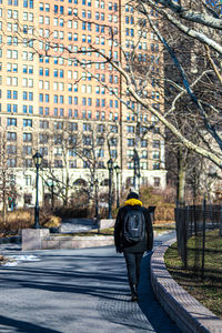 Rear view of man walking on road