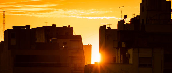 Silhouette of buildings against sky during sunset