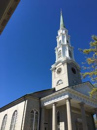 Low angle view of clock tower against blue sky