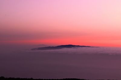 Scenic view of sea against dramatic sky during sunset