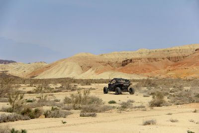 Black buggy in the desert in the sandy multi-colored ak-tau mountains in altyn-emel in summer