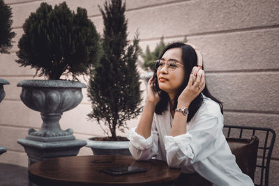 Portrait of young woman sitting on table