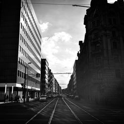 Road in city against cloudy sky