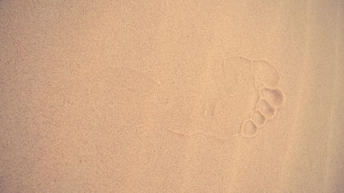 Directly above shot of footprint on sand