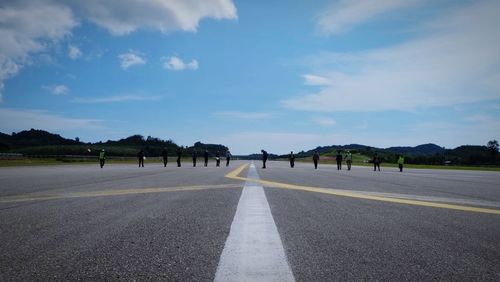 Full length of people standing at airport runway