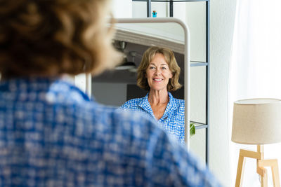 Side view of young woman looking away at home