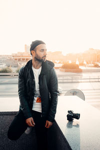 Young man looking at camera against sky