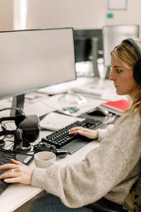 Midsection of woman using mobile phone while sitting on table