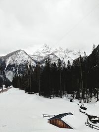 Ski lift over snowcapped mountains against sky.