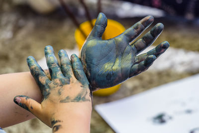 Cropped image of hands covered with colors