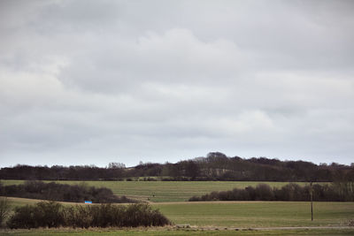 Scenic view of grassy field against cloudy sky