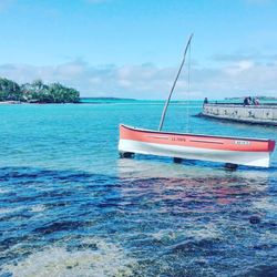 Boats in sea against cloudy sky